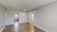 Located at 1015 W 41st Pl in Kansas City, MO, this single-floor, 3-bedroom, 1-bathroom home offers a practical and well-appointed layout. Dark hardwood flooring flows consistently throughout the living areas and bedrooms, complementing the neutral gray walls and crisp white trim for a clean, cohesive aesthetic.

The spacious living area features natural light from a large window with blinds, while the entry door provides convenient access. The primary bedroom is notably generous in size, offering ample space and its own closet access. The additional bedrooms each include ceiling fans with light fixtures, windows for natural light, and individual closet doors — notably, one room features a decorative embossed tile ceiling that adds a distinctive architectural touch.

The kitchen is efficiently designed with rich wood cabinetry, a tile backsplash, stone-look countertops, a stainless steel sink, and black appliances including a gas range and refrigerator. A window above the sink area brings in natural light. The hallway connects all rooms seamlessly, providing excellent flow throughout the home.

The bathroom includes a full tub/shower combination with white tile surround, a wood vanity with a large mirror, and tile flooring. Overall, this home presents a functional, well-maintained space with charming details throughout.