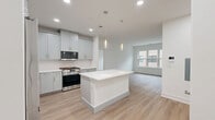 This thoughtfully designed 2-bedroom, 2-bathroom residence at 300 Main St in Madison, NJ offers a clean, modern aesthetic across a well-proportioned single-floor layout. The open-concept kitchen, dining, and living area serves as the heart of the home, anchored by a striking white center island with pendant lighting overhead. The kitchen is outfitted with soft gray shaker-style cabinetry, white quartz countertops, a herringbone tile backsplash, and stainless steel appliances including a gas range and French door refrigerator. Light wood-tone flooring flows seamlessly throughout the main living areas and bedrooms, enhancing the bright, airy ambiance created by recessed lighting and natural light from well-placed windows. The spacious primary bedroom offers a generous footprint with a dedicated closet, while the second bedroom provides a comfortable and versatile space. Both bathrooms are finished with large-format tile flooring, gray vanity cabinetry, white quartz countertops, and glass-enclosed shower or tub enclosures. Additional conveniences include in-unit laundry and an abundance of closet storage throughout. The overall design is cohesive, contemporary, and move-in ready.