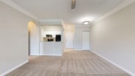 Located in Largo, FL, this well-designed one-bedroom, one-bathroom unit offers an efficient and comfortable single-floor layout. The open-concept living room is accessed through a graceful arched entryway and features neutral-toned carpet, crown molding, and a ceiling fan, creating a warm and inviting atmosphere. Natural light flows in from multiple windows, offering pleasant views of surrounding greenery.

The galley-style kitchen is thoughtfully appointed with white cabinetry, open shelving, granite-look countertops, a stainless steel sink, a dishwasher, and full-size appliances including a refrigerator and range. Light-toned tile flooring adds a clean, modern touch to the space.

The bedroom is generously sized with soft carpeting, a ceiling fan, and a window that frames lush outdoor views. It includes access to a walk-in closet with built-in shelving, providing ample storage. A hallway connects the main living areas to the private spaces of the unit.

The bathroom features white cabinetry with gold-toned hardware, granite countertops, an undermount sink, a full tub-shower combination with white tile surround, and wood-look flooring—delivering a clean and functional aesthetic throughout. The neutral color palette and consistent finishes lend the entire unit a cohesive, move-in-ready feel.