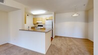 Located at 7575 Madison Ave in Citrus Heights, CA, this two-bedroom, two-bathroom residence offers a well-organized single-level floor plan designed for comfortable everyday living. The combined dining and living area provides an open, airy feel with neutral-toned carpet throughout, creating a clean and versatile space for a variety of furnishing arrangements. A peninsula kitchen connects seamlessly to the living area, featuring light wood cabinetry, a double sink, laminate countertops, a full suite of white appliances including a refrigerator, electric range, and dishwasher, and durable hardwood-style flooring. Both bedrooms are carpeted and bright, with the primary bedroom offering a sliding-door closet and a window with natural light and views of surrounding greenery. The second bedroom is equally well-proportioned with its own closet access. The unit includes two full bathrooms — one with a walk-in shower and hardwood-style flooring, and one with a soaking tub, both featuring vanities with grey countertops and large mirrors. Additional storage is provided through three closets distributed throughout the unit, complemented by an entrance foyer and a connecting hallway that ties the layout together efficiently.