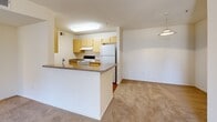 Located at 7575 Madison Ave in Citrus Heights, CA, this two-bedroom, two-bathroom residence offers a well-organized single-level floor plan designed for comfortable everyday living. The combined dining and living area provides an open, airy feel with neutral-toned carpet throughout, creating a clean and versatile space for a variety of furnishing arrangements. A peninsula kitchen connects seamlessly to the living area, featuring light wood cabinetry, a double sink, laminate countertops, a full suite of white appliances including a refrigerator, electric range, and dishwasher, and durable hardwood-style flooring. Both bedrooms are carpeted and bright, with the primary bedroom offering a sliding-door closet and a window with natural light and views of surrounding greenery. The second bedroom is equally well-proportioned with its own closet access. The unit includes two full bathrooms — one with a walk-in shower and hardwood-style flooring, and one with a soaking tub, both featuring vanities with grey countertops and large mirrors. Additional storage is provided through three closets distributed throughout the unit, complemented by an entrance foyer and a connecting hallway that ties the layout together efficiently.