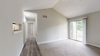 Located at 3475 Pleasantbrook Village Ln in Atlanta, GA, this 2-bedroom, 1-bathroom home offers a well-organized single-level layout with a thoughtful mix of flooring and architectural detail throughout. The living room is a standout space, featuring dramatic vaulted ceilings that lend an open, airy feel, along with a built-in wall niche and access to a private balcony overlooking greenery. Wood-look vinyl flooring anchors the living and kitchen areas, creating a clean, cohesive look. The kitchen is efficiently designed with white cabinetry, granite-style countertops, stainless steel appliances including a refrigerator and range, and a dedicated overhead light fixture. Both bedrooms are carpeted in neutral tones and filled with natural light from window treatments. The primary bedroom is a comfortable size and features its own dedicated closet with built-in shelving and hanging rods, offering ample storage. The second bedroom includes a sliding-door closet and connects conveniently to the hallway. The full bathroom is clean and functional, featuring a tub-shower combo with a built-in niche and wood-look flooring. Neutral gray-toned walls throughout the home provide a versatile backdrop. A connecting hallway ties all rooms together seamlessly.