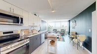 Located at 55 Chapel St S in Hartford, CT, this one-bedroom, one-bathroom unit offers a well-planned open layout that maximizes its compact footprint. The combined kitchen and living area forms the heart of the space, showcasing light wood-style flooring, two-tone cabinetry with dark lower and white upper cabinets, a white subway tile backsplash, and a full suite of stainless steel appliances. The open-plan design allows the kitchen to flow naturally into the living area, which is anchored by floor-to-ceiling windows that flood the space with natural light and frame expansive views of the Hartford skyline and surrounding landscape.

A distinctive sage-green accent wall adds depth and character to the living area, creating a stylish contrast to the otherwise light and airy palette. The bedroom continues the floor-to-ceiling window theme, offering the same panoramic city views and generous natural light. The bathroom features dark wood-tone cabinetry, a white countertop vanity, and clean white walls. A hallway with a closet provides practical storage. Overall, the space presents a modern, urban aesthetic with a bright, open ambiance suited to contemporary living.