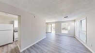 Located at 108 London Ct in Fayetteville, NC, this single-story, 3-bedroom, 2-bathroom home offers a thoughtfully arranged layout with consistent modern finishes throughout. Light gray wood-look flooring runs continuously across the living spaces, complementing the neutral, warm-toned walls and white trim that give the home a clean, cohesive aesthetic.

The living room is a standout space, featuring a textured ceiling, multiple windows, and a sliding glass door that fills the room with natural light and provides views of the surrounding greenery. The kitchen is outfitted with white cabinetry, gray laminate countertops, and an electric range with overhead ventilation.

The primary bedroom is a comfortably sized retreat with a ceiling fan, a window with blinds, and access to a dedicated closet with built-in shelving. The additional bedrooms also feature wood-look flooring and windows that let in natural light. A hallway connects the bedrooms to the two bathrooms, one of which includes a tub/shower combination with accessibility grab bars and a pedestal-style sink. A dedicated laundry area and two closets round out the functional layout of this well-appointed home.