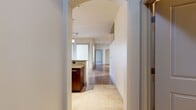 This 1,370-square-foot single-floor residence in Needham Heights, MA features 2 bedrooms and 3 bathrooms thoughtfully laid out for comfortable living. The open-concept kitchen and living area is anchored by a granite-topped peninsula, rich dark-wood cabinetry, stainless steel appliances, and warm hardwood flooring. Pendant and track lighting illuminate the space, while large windows invite generous natural light into the living room. The 170-square-foot primary bedroom includes a ceiling fan, plush carpeting, and access to an en-suite bathroom appointed with tile flooring, a granite vanity with dark-wood cabinetry, and a tiled soaking tub and shower. A spacious walk-in closet with wire shelving provides ample storage. The second bedroom also features carpet flooring, a ceiling fan, and a bright window with outdoor views. A dedicated in-unit laundry room houses a full-size washer and dryer with additional wire shelving. A private balcony extends the living space outdoors. Throughout the unit, neutral tones, consistent finishes, and a practical floor plan create a clean, functional, and comfortable living environment.
