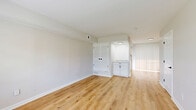 This two-story home in Columbus, Ohio offers a thoughtfully designed layout spread across two floors. The main level features a bright and open living room with light wood laminate flooring, neutral walls, and a large front-facing window that fills the space with natural light. A staircase with a classic white banister connects the levels. Adjacent to the living area is a galley-style kitchen outfitted with white shaker cabinets, black hardware accents, granite-style countertops, a stainless steel sink, and stainless steel appliances including a refrigerator and electric range—all set over matching wood-look flooring.

Upstairs, two carpeted bedrooms offer comfortable retreats, each featuring neutral tones, natural light from windows with blinds, and sliding double-door closets for ample storage. The primary bedroom provides a generous amount of space, with dual closets and a quiet, airy feel. The full bathroom is cleanly finished with white cabinetry, a single-sink vanity, a tub-shower combination, and black fixture accents that complement the wood flooring. A hallway connects the upper-level rooms, completing this clean, move-in-ready home.