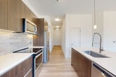 Located at 1500 Westbranch Dr in McLean, VA, this thoughtfully designed 3-bedroom, 2-bathroom residence offers a seamless blend of modern aesthetics and functional living across a single floor. Light hardwood flooring flows throughout, complementing the clean, neutral palette that defines the space.

The open-concept living, dining, and kitchen area serves as the heart of the home. The living room is anchored by dramatic floor-to-ceiling windows that flood the space with natural light and frame sweeping outdoor views of the surrounding landscape. The gourmet kitchen features rich walnut-toned cabinetry, white quartz countertops, a tiled backsplash, stainless steel appliances, and a large center island with pendant lighting — ideal for both cooking and entertaining. An adjacent pantry provides generous storage.

A bright hallway connects the private quarters, which include three well-proportioned bedrooms, each with ceiling fans and ample closet space. The spacious primary bedroom features a large window with outdoor views. The primary bathroom offers a walk-in glass shower with striking marble-style tile surround, while the second bathroom includes a soaking tub. Both bathrooms showcase modern floating vanities and large-format floor tiles. An in-unit laundry room adds everyday convenience.