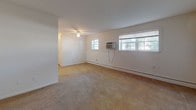 Located at 758 Christiana Rd in Newark, Delaware, this single-floor unit offers a practical and straightforward layout designed for comfortable everyday living. The living area is generously sized, featuring neutral wall-to-wall carpeting, a ceiling fan, and multiple windows that allow natural light to fill the space. A wall-mounted air conditioning unit and baseboard heating ensure year-round climate control. The kitchen is well-equipped with warm-toned wood cabinetry, light countertops, wood-look plank flooring, and a full suite of appliances including a gas range, dishwasher, and refrigerator. Ample upper and lower cabinet storage makes the kitchen both functional and organized. The bedroom continues the carpeted flooring found throughout the living spaces, with a louvered closet door providing storage, and baseboard heating for added comfort. The full bathroom features classic grey and white square tile along the walls and a mosaic tile floor, complemented by a pedestal sink, a mirror medicine cabinet, and a tub-shower combination. The clean, white walls and simple finishes throughout the unit create a bright, neutral environment ready for personalization.