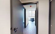 Located at 401 E State St in Ithaca, NY, this modern one-bedroom, one-bathroom unit offers a thoughtfully designed layout with contemporary finishes throughout. Light wood-tone flooring flows seamlessly across the living spaces, complemented by dark-trimmed doors and bold navy baseboards that add a striking contrast to the crisp white walls.

The kitchen serves as the centerpiece of the unit, featuring slate-blue cabinetry, a subway tile backsplash, stone countertops, and stainless steel appliances including a full-size refrigerator, dishwasher, and microwave. A uniquely shaped kitchen island with a rounded pedestal base and white surface provides additional prep and dining space, topped by a sleek multi-globe pendant light fixture. Large black-framed windows flood the kitchen and living area with natural light and offer views of the surrounding Ithaca landscape.

The bedroom is a well-proportioned, quiet retreat with wood-look flooring, neutral walls, and a wide bank of black-framed windows that bring in ample daylight and outdoor views. The bathroom features large-format tile flooring, a glass-enclosed shower, and clean, minimalist fixtures. A dedicated closet and hallways complete the efficient, functional floor plan of this modern Ithaca residence.