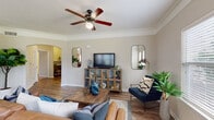 This single-floor, 2-bedroom, 2-bathroom residence in Memphis, TN offers a thoughtfully designed layout with consistent finishes throughout. The living room serves as the heart of the home, featuring rich wood-look flooring, crown molding, and a ceiling fan overhead. Multiple windows allow natural light to fill the space, while an open sightline connects to the kitchen, enhancing the sense of openness.

The kitchen is well-equipped with warm wood cabinetry extending to the ceiling for ample storage, dark granite-style countertops, a double basin sink, and black appliances including a refrigerator and dishwasher. A peninsula provides additional prep space and a casual dining option. A back door offers convenient exterior access.

Both bedrooms feature plush carpeting, ceiling fans, and crown molding. The primary bedroom includes a spacious walk-in closet with built-in wire shelving on multiple walls, providing generous storage capacity.

Each bathroom mirrors the other with wood-look flooring, warm wood vanity cabinetry, dark countertops, and a tiled tub-shower combination. The neutral color palette maintained throughout the home creates a cohesive and calm ambiance.