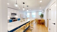Located at 55 Tunxis Ave in Bloomfield, CT, this thoughtfully designed one-bedroom, one-bathroom residence offers a bright and modern living experience across a single floor. The open-concept layout seamlessly connects the kitchen, dining, and living areas, creating a cohesive and functional space bathed in natural light from multiple windows.

The kitchen is a standout feature, showcasing bold navy blue lower cabinetry paired with crisp white upper cabinets and quartz countertops. Stainless steel appliances — including a refrigerator, range, microwave, and dishwasher — complement the sleek tile backsplash and globe pendant lighting above the kitchen island, which doubles as a breakfast bar. Light hardwood flooring flows throughout the main living areas, adding warmth to the contemporary aesthetic.

The bedroom is a serene retreat, featuring dual windows with roller shades, a wall-mounted mini-split HVAC unit, and recessed lighting. The space offers comfortable proportions ideal for rest and relaxation.

The bathroom is finished with large-format marble-look wall tiles and contrasting dark floor tiles, centered around a walk-in shower with matte black fixtures for a refined, modern touch. An in-unit stacked washer and dryer adds everyday convenience. Overall, the space exudes a clean, modern ambiance with carefully curated design details throughout.