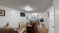 Located at 1300 Ridgefield Ave in Thibodaux, Louisiana, this single-story 2-bedroom, 1-bathroom home offers a well-organized and functional layout across its compact footprint. The interior is finished with warm hardwood flooring throughout the main living areas and bedrooms, complemented by neutral gray-toned walls and textured ceilings.

The living room serves as the heart of the home, offering enough space for a full seating arrangement and a wall-mounted television. A window dressed with sheer curtains allows natural light to filter in, creating a bright and welcoming atmosphere. The living area flows toward a dining space and kitchen, visible through the open hallway.

Both bedrooms are comfortably sized, each featuring hardwood floors, windows for natural light, and ample closet space. The primary bedroom includes a double closet, providing practical storage. The second bedroom similarly offers a dresser-height window and generous storage.

The single bathroom is clean and functional, finished with light tile flooring, a vanity with white cabinetry, and a shower-tub combination. A ventilation window adds airflow to the space.

A connecting hallway ties all rooms together efficiently, making the overall flow of this home logical and easy to navigate. This property offers straightforward, comfortable living in a well-established Thibodaux neighborhood.