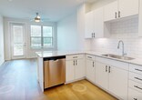 Located at 770 Collins Hill Rd in Lawrenceville, GA, this efficient 570-square-foot, single-story unit offers a thoughtfully designed layout across one bedroom, one bathroom, a kitchen, and a dedicated laundry area. The open living and kitchen area features light hardwood-style flooring and crisp white walls, creating a bright and clean aesthetic throughout. The modern kitchen is equipped with stainless steel appliances—including a side-by-side refrigerator, electric range, over-the-range microwave, and dishwasher—complemented by white shaker cabinetry with matte black hardware, a subway tile backsplash, and granite countertops. The 120-square-foot bedroom is finished with plush carpet, a ceiling fan with light fixture, and a window with blinds that allows natural light and outdoor views. The bathroom continues the contemporary design with a double-sink vanity featuring granite countertops, white cabinetry with matte black hardware, a large mirror, and a tiled shower. The in-unit laundry area includes a full-size Whirlpool washer and dryer with overhead shelving. Five-panel interior doors and visible HVAC vents complete the clean, modern character of this well-appointed unit.