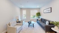 Located at 3624 N Conrad St in Philadelphia's East Falls neighborhood, this single-floor unit showcases contemporary design throughout. Light hardwood flooring runs through most of the space, complemented by neutral gray and white walls and recessed lighting that create a clean, modern aesthetic.

The kitchen is a standout feature, combining navy blue lower cabinets with light wood upper cabinetry and white countertops. A peninsula with seating provides additional prep and dining space, while stainless steel appliances, including a range, microwave, and refrigerator, complete the setup. A white subway tile backsplash adds a classic touch. A wall-mounted mini-split system provides climate control throughout the unit.

The living area benefits from two windows framing greenery views, filling the room with natural light. Adjacent rooms offer flexible use with hardwood floors and window access to outdoor views.

Two bathrooms serve the unit. One features dark tile flooring, a tub-shower combo with large-format tile surround, and clean white fixtures. The second offers a modern floating wood vanity, a wide rectangular mirror with black trim, and dark tile flooring.

Overall, the space presents a well-finished, move-in-ready environment with thoughtful design details throughout.