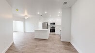 Located at 2089 Heritage Key Blvd in Kissimmee, FL, this single-floor, two-bedroom, two-bathroom home offers a clean, modern aesthetic defined by crisp white walls, light wood-style flooring, and recessed lighting throughout. The open-concept layout connects the kitchen and living areas seamlessly, creating a bright and airy atmosphere. The kitchen is a standout feature, equipped with stainless steel appliances including a refrigerator, range, and microwave, complemented by white shaker-style cabinetry, a white countertop island, and recessed lighting overhead. A ceiling fan adds comfort to the adjoining living area. Both bedrooms are well-proportioned, with the primary bedroom offering an en-suite bathroom and a dedicated walk-in closet outfitted with wire shelving. The second bedroom benefits from a large window that brings in natural light and neighborhood views. The bathrooms feature white vanities with ample drawer storage, large mirrors, and a tub-shower combination. Two closets, a hallway, and two living areas round out the thoughtfully organized floor plan. The consistent light flooring and neutral palette throughout lend the home a cohesive, move-in-ready appeal.