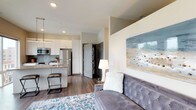 Located at 985 N High St in Columbus, Ohio's vibrant Short North neighborhood, this contemporary single-floor residence offers a thoughtfully designed open-concept layout. The living area is bright and welcoming, featuring warm-toned walls, recessed lighting, and rich hardwood-style flooring that runs throughout the unit. Large windows and a sliding glass door flood the space with natural light while offering sweeping views of the surrounding Columbus cityscape, with direct access to a private balcony.

The kitchen is a standout feature, outfitted with crisp white cabinetry extending to the ceiling, a subtle tile backsplash, granite countertops, and a full suite of stainless steel appliances including a refrigerator, range, and built-in microwave. A peninsula with seating provides a casual dining option and reinforces the open connection between the kitchen and living space.

The bathroom is clean and well-appointed, featuring a granite-topped vanity with white cabinetry, hardwood-style flooring, and neutral wall tones that lend a modern, polished feel. In-unit laundry is conveniently tucked within the space, adding practical functionality. The overall design balances contemporary finishes with a comfortable, livable atmosphere ideal for urban living.