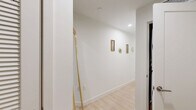 Located along N Federal Hwy in Fort Lauderdale, FL, this modern residence offers four bedrooms and two bathrooms across a thoughtfully designed single-floor layout. Light wood flooring flows throughout, complementing a clean, neutral color palette that enhances the sense of openness.

The kitchen is a standout feature, showcasing two-tone cabinetry with white uppers and warm wood lowers, quartz countertops, a penny tile backsplash, and stainless steel appliances. A round dining table sits adjacent, creating a seamless kitchen-dining area.

The living room is bathed in natural light through floor-to-ceiling sliding glass doors that open to views of the surrounding Fort Lauderdale streetscape, fitted with sleek roller shades for privacy. The primary bedroom is generously sized with a large picture window framing outdoor views.

Additional bedrooms are bright and well-proportioned, each with large windows. The primary bathroom features a soaking tub, sliding glass-enclosed shower with bold vertical navy blue tile, a wood-toned vanity, and light wood floors. A second, more compact bathroom offers a clean vanity and hardwood flooring. A dedicated closet completes the functional layout of this contemporary Fort Lauderdale residence.