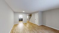 Located at 220 E Hoover Dr in Fort Wayne, Indiana, this two-story, 2-bedroom, 2-bathroom home offers a well-organized layout spread evenly across two floors. The main level features an open-concept combined dining and living area finished with light wood luxury vinyl flooring and neutral gray walls, creating a bright and welcoming atmosphere. A sliding glass door floods the living space with natural light and provides views of the outdoors. The kitchen is thoughtfully updated with two-tone cabinetry — white upper cabinets and gray lower cabinets — paired with marble-style countertops, a white subway tile backsplash, black appliances, and a double-basin sink beneath a window. A dedicated laundry area and closet storage add practical convenience on this level. A carpeted staircase with a black metal railing leads to the upper floor, where both bedrooms are located. The bedrooms feature neutral carpet and soft wall tones, offering a calm retreat. The primary bedroom provides a comfortable footprint with ample space. Two full bathrooms serve the home, one of which includes a tiled tub/shower combo with black hardware accents and wood-style flooring. Three closets throughout the home offer generous storage for a two-story residence of this scale.