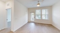 Located at 5151 Patriarch Place North in North Augusta, SC, this one-bedroom, one-bathroom residence offers a thoughtfully designed single-floor layout with clean, modern finishes throughout. Light wood-look flooring flows seamlessly through every room, creating a bright and cohesive aesthetic.

The kitchen serves as a true centerpiece, featuring white shaker-style cabinetry extending to the ceiling, white quartz countertops, a classic subway tile backsplash, stainless steel appliances including a range, over-the-range microwave, and refrigerator, and a central island with a black undermount sink and pendant lighting above. Recessed lighting enhances the open, airy feel.

The living area is generously proportioned, benefiting from large windows that invite natural light and offer outdoor views, a ceiling fan, and direct access to the exterior via a glass-panel door. The bedroom is a comfortable retreat with its own ceiling fan, a large window with outdoor views, and clean white walls.

The bathroom is finished in a contemporary style, showcasing a white vanity with quartz countertop, black hardware accents, a framed mirror with modern lighting, and continued wood-look flooring. A dedicated closet provides additional storage. The overall ambiance is fresh, minimalist, and move-in ready.