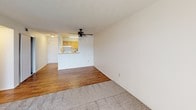 This single-floor unit offers a practical and well-organized layout designed for comfortable everyday living. The open-concept living area features a combination of hardwood-style flooring and plush wall-to-wall carpet, creating a warm and inviting atmosphere. A ceiling fan with a light fixture adds both functionality and a subtle design touch to the main living space. Large sliding glass doors with vertical blinds allow generous natural light to fill the room while providing access to an outdoor view, enhancing the sense of openness.

The kitchen is efficiently designed with warm honey-toned wood cabinetry, light countertops, and a white electric range with an overhead ventilation hood. A pass-through or adjacent opening connects the kitchen to the living area, maintaining an airy, connected feel throughout the common spaces.

The bedrooms are carpeted and finished with neutral-toned walls, offering a clean and versatile canvas. Windows in the bedrooms provide natural light and views of the surrounding area.

The bathroom is finished with large-format gray tile extending from floor to ceiling in the tub-shower surround, complemented by a white soaking tub, a standard toilet, and a wood-toned vanity with a light countertop. A textured ceiling is consistent throughout the unit, adding a classic residential character to the overall space.
