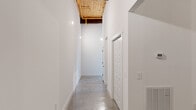 Located at 1812 Slaton Street in Augusta, Georgia, this one-bedroom, two-bathroom space delivers a bold industrial aesthetic across a generously sized single-floor layout. Polished concrete floors run throughout, complementing crisp white walls and creating a sleek, modern foundation that lets the raw architectural details take center stage.

The living area is a standout, featuring soaring ceilings clad in warm wood planking, corrugated metal accent walls framed by dark steel, and a row of high clerestory windows that draw in natural light. An exposed brick wainscoting runs along the base of the walls, while an oversized ceiling fan anchors the space both functionally and visually.

The hallways are wide and airy, with the wood-planked ceilings and exposed piping overhead adding to the industrial character. The spacious primary bedroom showcases a dramatic full wall of original exposed brick, paired with polished concrete floors and exposed ductwork above — a nod to the building's heritage.

Both bathrooms are thoughtfully finished with teal shaker-style vanities, granite countertops, round gold-framed mirrors, and matte black fixtures. One bathroom features a tiled tub-shower combination with a built-in niche. A walk-in closet with wire shelving and a dedicated laundry room complete this distinctive and well-appointed space.