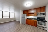 This two-bedroom, two-bathroom residence at 2200 W Cornwallis Drive in Greensboro, NC offers a well-organized single-floor layout designed for comfortable everyday living. The kitchen is outfitted with warm-toned wood cabinetry, dark granite-style countertops, a white subway tile backsplash, and a full suite of stainless steel appliances including a refrigerator, electric range, and over-the-range microwave. Durable hardwood-style flooring runs throughout the kitchen and living areas, creating a cohesive and easy-to-maintain surface. Both bedrooms feature plush carpeting and ceiling fans, providing comfort and air circulation. The spacious primary bedroom includes direct access to its own bathroom and benefits from generous natural light through large windows with blinds. The second bedroom also offers wide windows and a ceiling fan. Each bathroom is thoughtfully appointed — one features a rich wood vanity with a warm stone countertop and mirrored medicine cabinet, while the second offers a compact dark vanity with a mirror cabinet. A connecting hallway with closets provides practical storage. The layout flows efficiently, making the most of every square foot in this cozy Greensboro residence.