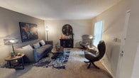 This single-floor, 2-bedroom, 2-bathroom residence offers a thoughtfully arranged layout designed for comfortable everyday living. The living room serves as the heart of the home, featuring plush carpeting, neutral-toned walls, and a large window with vertical blinds that allows natural light to fill the space. The room comfortably accommodates a seating arrangement anchored by a bold area rug, creating a warm and inviting atmosphere.

The kitchen stands out with its vibrant accent wall, generous countertop space, double stainless steel sink, wood-toned cabinetry, and hardwood-style flooring. A pass-through connects the kitchen to the adjacent dining area, enhancing the open flow of the space.

The primary bedroom is spacious and well-lit, featuring a ceiling fan with light fixture, carpet flooring, a large window with drapes, and ample room for a full furniture arrangement. The second bedroom mirrors this comfort with its own ceiling fan and natural light.

Both bathrooms are functionally designed. One features a vanity with a wide countertop, dark wood cabinetry, a framed mirror, and hardwood-style flooring. The second includes a full tub-shower combination with tile surround.

Throughout the residence, textured ceilings, neutral wall tones, and consistent flooring choices create a cohesive and practical living environment.