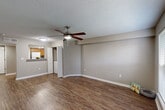 Located at 2408 Houma Blvd in Metairie, Louisiana, this single-story, one-bedroom, one-bathroom unit offers a practical and well-maintained layout across a comfortable footprint. The living room serves as the central gathering space, featuring durable wood-look flooring, neutral gray walls, white baseboards, a textured ceiling, and a ceiling fan with integrated lighting. A window with blinds allows natural light to fill the room, creating a bright and open feel. The layout flows seamlessly into the kitchen, which is outfitted with warm honey-toned wood cabinetry, granite-style countertops, a mosaic tile backsplash, white appliances including a range and refrigerator, and a stainless steel sink. A hallway connects the main living areas to the private bedroom, which is carpeted for comfort and features its own ceiling fan, a window with blinds, and ample wall space. The bathroom includes a wood-toned vanity with a granite-style countertop, wood-look flooring, and a shower-tub combination. A dedicated closet and multiple hallways provide functional storage and circulation throughout the unit. The overall design is clean and cohesive, with consistent neutral tones and practical finishes throughout.