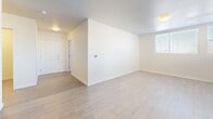 Located at 14475 Montview Blvd in Aurora, CO, this two-bedroom, one-bathroom unit offers a thoughtfully organized single-floor layout. Light-toned wood-look flooring runs consistently throughout, creating a cohesive and clean aesthetic across every room. The open living area is bright and airy, with neutral white walls and natural light filtering in through blinded windows.

The kitchen is a functional standout, featuring rich dark brown cabinetry that extends to the ceiling for ample storage, light-toned countertops, and a full suite of black appliances including a refrigerator, dishwasher, electric range, and over-the-range microwave. Track lighting and a large window enhance the workspace.

Both bedrooms are comfortably sized, with the primary bedroom offering a well-proportioned footprint. Each room features light wood-look flooring, ceiling fan fixtures, and clean white walls. The bedrooms also include individual wall-mounted HVAC units for climate control.

The bathroom is finished with a full soaking tub and shower combination, chrome fixtures, and tile-look flooring that complements the unit's overall palette. A dedicated laundry room accommodates a stacked washer and dryer unit, adding everyday convenience. A closet rounds out the storage available throughout the home.