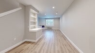 This three-story unit at 4233 Verda Ln NE in Keizer, Oregon, offers a well-organized layout across three distinct levels. The ground floor houses an attached garage equipped with an automatic opener, a translucent paneled door that allows natural light in, and an electrical panel — providing both secure parking and utility access.

The main living level serves as the social hub of the unit, featuring an open-concept kitchen and living room. The kitchen is outfitted with white shaker cabinetry, quartz countertops, a stainless steel dishwasher, a matte black faucet, and a window overlooking greenery. The adjacent living area includes recessed lighting, a built-in electric fireplace, integrated shelving, and light wood-look flooring that flows throughout.

The upper floor accommodates all three bedrooms, three bathrooms, hallways, and two closets. The bedrooms feature neutral wall tones, natural light from windows with outdoor views, and light hardwood-style flooring. The bathrooms are finished with white shaker vanities, quartz countertops, matte black fixtures, and modern rectangular mirrors. Closets include built-in shelving and hanging rods. Two staircases connect the floors, enhancing circulation throughout this thoughtfully designed multi-level home.