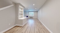 This three-story unit at 4233 Verda Ln NE in Keizer, Oregon, offers a well-organized layout across three distinct levels. The ground floor houses an attached garage equipped with an automatic opener, a translucent paneled door that allows natural light in, and an electrical panel — providing both secure parking and utility access.

The main living level serves as the social hub of the unit, featuring an open-concept kitchen and living room. The kitchen is outfitted with white shaker cabinetry, quartz countertops, a stainless steel dishwasher, a matte black faucet, and a window overlooking greenery. The adjacent living area includes recessed lighting, a built-in electric fireplace, integrated shelving, and light wood-look flooring that flows throughout.

The upper floor accommodates all three bedrooms, three bathrooms, hallways, and two closets. The bedrooms feature neutral wall tones, natural light from windows with outdoor views, and light hardwood-style flooring. The bathrooms are finished with white shaker vanities, quartz countertops, matte black fixtures, and modern rectangular mirrors. Closets include built-in shelving and hanging rods. Two staircases connect the floors, enhancing circulation throughout this thoughtfully designed multi-level home.
