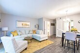 Located at 461 Forest Hill Rd in Macon, Georgia, this two-floor residence offers a well-appointed layout designed for comfortable everyday living. The kitchen is a standout feature, showcasing crisp white cabinetry, granite-look countertops, a dark subway tile backsplash, and black appliances including a range, microwave, dishwasher, and refrigerator. Natural light filters in through a window above the sink, complemented by wood-look flooring throughout. The kitchen flows seamlessly into a dedicated dining area, which is anchored by a modern chandelier, warm-toned wall art, and a light wood dining table surrounded by upholstered chairs. The living room provides a welcoming atmosphere with a spacious sectional sofa, accent seating, parquet-style flooring, and vertical blinds that allow for adjustable natural light. The bedroom features carpet flooring, multiple windows with views of surrounding greenery, and tasteful decorative accents. The bathroom includes a full tub-shower combination with coordinating fixtures. Throughout the home, neutral gray walls and carefully chosen décor create a cohesive, contemporary aesthetic that is both functional and inviting.