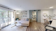 Located in Atlanta's vibrant Virginia-Highland neighborhood, this two-bedroom, one-bathroom residence offers a well-designed single-floor layout with a clean, modern aesthetic throughout. Wood-look flooring flows continuously across the living spaces, anchoring the bright, neutral palette that defines the interior.

The living room is a welcoming, light-filled space anchored by a large sliding glass door that opens to a private balcony with leafy outdoor views, allowing natural light to pour in. Adjacent to the living area, the dining space provides an intimate setting, while the kitchen impresses with two-tone cabinetry — crisp white uppers paired with slate-gray lowers — white quartz countertops, stainless steel appliances, a skylight, and a peninsula with bar seating that creates a seamless connection between kitchen and dining.

The primary bedroom is a comfortably sized retreat featuring a ceiling fan and hardwood-style flooring, while the second bedroom also offers a ceiling fan, a natural light window, and a relaxed, cozy feel. The full bathroom includes a tiled shower-tub combination. A dedicated in-unit laundry room with full-size washer and dryer adds everyday convenience, complemented by hallway access and a separate closet for storage.