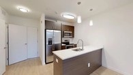 Located at 550 Halstead Avenue in Harrison, NY, this well-appointed one-bedroom, one-bathroom residence offers a thoughtfully designed single-floor layout with modern finishes throughout. Light-toned hardwood flooring flows seamlessly across the open-concept living and kitchen areas, creating a bright, cohesive aesthetic.

The kitchen is a standout feature, showcasing rich dark-walnut cabinetry, a suite of stainless steel appliances including a French-door refrigerator with ice maker, electric range, and built-in microwave. A peninsula with a crisp white countertop and undermount sink doubles as a breakfast bar, illuminated by stylish pendant lighting overhead.

The living area is generously proportioned with clean white walls and a large window that fills the room with natural light and frames outdoor views of the surrounding greenery. The bedroom continues the same light wood flooring and neutral palette, featuring a dedicated closet for ample storage.

The bathroom is finished to a high standard, featuring large-format grey tile walls in the walk-in shower, a sleek dark-wood vanity with a glass-top sink, a backlit mirror, and neutral tile flooring — delivering a clean, spa-like atmosphere. The overall design is modern, minimal, and move-in ready.