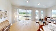 Located at 2175 Sagebrush Rd in Missoula, Montana, this well-designed two-story home offers three bedrooms, two bathrooms, and an attached garage across a thoughtfully laid-out floor plan. The main living level commands attention with its open-concept kitchen and dining area, where soaring ceilings and recessed lighting create an airy, welcoming atmosphere. The kitchen is outfitted with warm wood cabinetry, stainless steel appliances, a white subway tile backsplash, and a central island with bar seating — all set atop light hardwood flooring. Large sliding and picture windows in the dining area frame sweeping views of the Montana landscape and distant mountains, flooding the space with natural light. The two bathrooms are finished with crisp white subway tile; one features a tub-shower combination and the other a walk-in shower. The bedrooms are calm and understated, with clean white walls and ample natural light, including a secondary bedroom well-suited as a home office with dual windows. The attached garage offers a polished concrete floor, automatic opener, and utility access including an electrical panel and HVAC equipment, providing practical functionality to complement the home's modern aesthetic.
