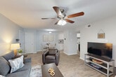 Located on Jefferson Highway in Baton Rouge, Louisiana, this single-floor 2-bedroom, 2-bathroom residence offers a thoughtfully designed layout with modern finishes throughout. The open-concept living and dining area serves as the heart of the home, featuring wood-look flooring, soft neutral walls, and a ceiling fan that enhances airflow and comfort. A sliding glass door floods the living room with natural light and provides direct access to an outdoor area. The kitchen is well-equipped with crisp white shaker-style cabinetry, granite-look countertops, black appliances, and a functional galley-style layout that maximizes efficiency. The primary bedroom offers a comfortable retreat with a ceiling fan, natural light from a window, and hardwood-style flooring. The second bedroom mirrors this clean, neutral aesthetic with its own ceiling fan and mirror accent. Both bathrooms are finished with white vanity cabinetry, granite-top counters, and well-lit mirrors, with one bathroom featuring a shower-tub combination. A connecting hallway links all rooms seamlessly, contributing to the efficient flow of the floor plan. The overall ambiance is clean, bright, and contemporary, making this residence a practical and attractive living space.