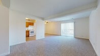 This 2-bedroom, 1-bathroom residence in Lawrence, Kansas offers a practical and comfortable single-floor layout. The open-concept living room is spacious and bright, featuring neutral carpet, a ceiling fan, and a large sliding glass door with vertical blinds that floods the space with natural light and provides access to an outdoor area. The layout connects seamlessly to the kitchen, which is well-equipped with warm oak cabinetry, ample counter space, and white appliances including a refrigerator, electric range, and dishwasher, all set over easy-to-maintain wood-look flooring.

The primary bedroom is generously sized, featuring soft carpet, a ceiling fan, a window with outdoor views, and a closet for storage. The second bedroom is similarly finished with carpet, neutral walls, and a ceiling light fixture. Both rooms offer a clean, versatile canvas. The full bathroom includes a tub-shower combination, wood-look tile flooring, a single-sink vanity with oak cabinetry, and clean white walls. Two hallways connect the rooms efficiently, and an additional closet provides extra storage. The unit's straightforward layout and bright, neutral interiors make it a functional and inviting home.