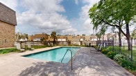 Located at 2727 S Rhode Island Ave in St. Louis Park, Minnesota, this outdoor pool area serves as a welcoming recreational amenity set within a well-maintained residential community. The centerpiece is a generously sized rectangular swimming pool with clear, blue-tinted water, featuring a depth range that accommodates both shallow and deeper swimming. The pool is finished with classic tiled edging and includes metal entry rails for convenient access.

Surrounding the pool is a spacious concrete patio deck that provides ample room for relaxation and movement. Several lounge chairs are arranged along the poolside, offering residents a comfortable space to unwind outdoors. The area is enclosed by a black iron fence, providing both security and a defined boundary for the space.

Mature trees frame the perimeter of the pool area, offering natural shade and contributing to a pleasant, park-like atmosphere. Seasonal plantings and greenery add color and vibrancy along the fenced borders. The adjacent multi-story brick and stucco residential buildings are visible in the background, reinforcing the community-oriented character of the space.

Overall, the pool area presents a clean, functional, and inviting outdoor environment well-suited for warm-weather recreation in the heart of St. Louis Park.