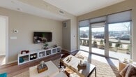 This one-bedroom, one-bathroom residence at 880 Pacific St in Stamford, Connecticut, offers a thoughtfully designed, single-floor layout with modern finishes and a bright, welcoming ambiance. The open-concept living area features warm hardwood-style flooring, neutral wall tones, and a large sliding glass door that floods the space with natural light while providing direct outdoor views. The kitchen is well-appointed with light wood cabinetry extending to the ceiling, a subway tile backsplash, stainless steel appliances including a gas range and refrigerator, and a central island with seating — ideal for casual dining or entertaining. The bedroom is a comfortable retreat, benefiting from a large window with exterior views, ample closet space with built-in shelving, and a serene, neutral color palette. The full bathroom is finished with contemporary gray cabinetry, a quartz countertop, hardwood-style flooring, and a backlit vanity mirror that adds a clean, modern touch. Throughout the residence, consistent flooring, clean lines, and a cohesive neutral palette create a polished and functional living environment well-suited for modern urban living in Stamford.