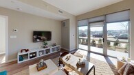 This one-bedroom, one-bathroom residence at 880 Pacific St in Stamford, Connecticut, offers a thoughtfully designed, single-floor layout with modern finishes and a bright, welcoming ambiance. The open-concept living area features warm hardwood-style flooring, neutral wall tones, and a large sliding glass door that floods the space with natural light while providing direct outdoor views. The kitchen is well-appointed with light wood cabinetry extending to the ceiling, a subway tile backsplash, stainless steel appliances including a gas range and refrigerator, and a central island with seating — ideal for casual dining or entertaining. The bedroom is a comfortable retreat, benefiting from a large window with exterior views, ample closet space with built-in shelving, and a serene, neutral color palette. The full bathroom is finished with contemporary gray cabinetry, a quartz countertop, hardwood-style flooring, and a backlit vanity mirror that adds a clean, modern touch. Throughout the residence, consistent flooring, clean lines, and a cohesive neutral palette create a polished and functional living environment well-suited for modern urban living in Stamford.