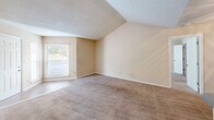 Located at 143 Stoneridge Dr in Columbia, SC, this single-floor residence offers two bedrooms and two bathrooms within a well-organized layout. The kitchen is equipped with warm oak cabinetry, grey laminate countertops, a double stainless steel sink, a black electric range, dishwasher, and refrigerator, all complemented by hardwood-style flooring. Ample upper and lower cabinet storage makes this an efficient and practical cooking space. The living area features neutral beige carpet and a sliding glass door that invites natural light and provides access to an outdoor space. The spacious primary bedroom includes vaulted ceiling detail, a large window with outdoor views, and a private en-suite bathroom with a tub/shower combo, tile surround, a vanity with storage, and hardwood-style flooring. A dedicated closet adjoins the primary bedroom, offering generous storage. The second bedroom is similarly carpeted with a large window that frames natural light and outdoor tree views. The second full bathroom mirrors the first in design, featuring a tub/shower, tile surround, a wood-toned vanity, and hardwood-style flooring. Throughout the residence, neutral tones and textured ceilings create a consistent, clean aesthetic.