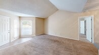 Located at 143 Stoneridge Dr in Columbia, SC, this single-floor residence offers two bedrooms and two bathrooms within a well-organized layout. The kitchen is equipped with warm oak cabinetry, grey laminate countertops, a double stainless steel sink, a black electric range, dishwasher, and refrigerator, all complemented by hardwood-style flooring. Ample upper and lower cabinet storage makes this an efficient and practical cooking space. The living area features neutral beige carpet and a sliding glass door that invites natural light and provides access to an outdoor space. The spacious primary bedroom includes vaulted ceiling detail, a large window with outdoor views, and a private en-suite bathroom with a tub/shower combo, tile surround, a vanity with storage, and hardwood-style flooring. A dedicated closet adjoins the primary bedroom, offering generous storage. The second bedroom is similarly carpeted with a large window that frames natural light and outdoor tree views. The second full bathroom mirrors the first in design, featuring a tub/shower, tile surround, a wood-toned vanity, and hardwood-style flooring. Throughout the residence, neutral tones and textured ceilings create a consistent, clean aesthetic.