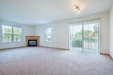 Located at 6735 Pinelake Dr in Madison, Wisconsin, this single-floor, two-bedroom, two-bathroom home offers a well-organized and functional layout. An inviting entrance hallway leads into the heart of the home, where the kitchen and living room share an open, connected layout. The kitchen is outfitted with warm oak cabinetry, a double-basin sink set into a peninsula counter, a full suite of appliances including a refrigerator, electric range, and dishwasher, and durable hardwood-style flooring. The adjacent living room is generously sized, featuring a corner fireplace with a wood-trimmed mantle and multiple windows that bring in abundant natural light, all set over plush wall-to-wall carpeting. Both bedrooms are comfortably proportioned, with soft carpeting, neutral walls, and warm wood-trimmed closet doors. The spacious primary bedroom includes a sliding glass door that opens to views of the surrounding neighborhood. Four closets throughout the home provide ample storage. The two bathrooms are finished with tile flooring, oak vanities, and full tub-shower combinations. A patio extends the living space outdoors, overlooking a well-kept residential streetscape with mature trees. The home's consistent warm wood trim and neutral palette create a cohesive and welcoming atmosphere throughout.
