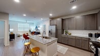Located on Stuebner Airline Road in Spring, Texas, this single-story residence offers a thoughtfully designed layout across two bedrooms and two bathrooms. The open-concept kitchen serves as a central highlight, featuring dark espresso-toned cabinetry with brushed hardware, granite countertops, a white subway tile backsplash, and a full suite of stainless steel appliances. A large kitchen island with a built-in sink and seating provides additional prep space and a natural transition into the living area. Light wood-style flooring runs throughout the home, contributing to a clean, cohesive aesthetic.

The living room is bright and comfortable, benefiting from natural light through a large window and a ceiling fan overhead. Both bedrooms are similarly well-lit, each featuring ceiling fans and windows with blinds. The primary bedroom includes a spacious walk-in closet outfitted with wire shelving systems on multiple walls, offering organized and functional storage. A second closet provides additional storage space.

The primary bathroom features dark wood cabinetry, a granite-topped double vanity, a large mirror, and direct access to the walk-in closet. Neutral tones and consistent finishes throughout the home create a modern and cohesive living environment.