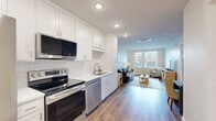 Located at 4301 Old William Penn Highway in Pittsburgh, PA, this well-appointed one-bedroom, one-bathroom unit offers a thoughtfully designed open-concept layout with modern finishes throughout. Wide-plank hardwood-style flooring flows seamlessly from the kitchen through the living area, creating a cohesive and inviting atmosphere.

The kitchen is a standout feature, outfitted with crisp white shaker cabinetry, white quartz countertops, a classic subway tile backsplash, and a full suite of stainless steel appliances including a refrigerator, electric range, over-the-range microwave, and dishwasher. The layout opens directly into the living room, which is bathed in natural light from large windows with clean white blinds.

The spacious bedroom offers plush carpeting, a bright window, and convenient direct access to the in-unit laundry area, which houses a stacked washer and dryer. A dedicated closet provides additional storage.

The bathroom features classic black-and-white mosaic tile flooring, a white vanity with modern brushed nickel fixtures, and a full tub-shower combination with white tile surround. Recessed lighting throughout the unit adds to its clean, contemporary feel. This unit combines functional design with modern aesthetics in a compact, efficient footprint.