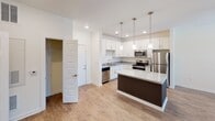 Located at 1000 Infinity Dr in Maryville, Tennessee, this well-appointed single-floor residence offers a thoughtfully designed open-concept layout that seamlessly connects the kitchen, dining, and living areas. The kitchen serves as a true centerpiece, showcasing a large island with a striking granite countertop, espresso-toned cabinetry, crisp white upper cabinets, and a full suite of stainless steel appliances including a refrigerator, range, microwave, and dishwasher. Pendant lighting above the island adds a refined finishing touch. The living and dining areas feature warm hardwood-style flooring and are bathed in natural light from large windows and a glass exterior door, which also provides outdoor access. A ceiling fan overhead enhances comfort throughout the space. Bedrooms are carpeted for warmth and comfort, each equipped with a ceiling fan and ample natural light from well-positioned windows. The bathroom is clean and functional, offering a full tiled tub-shower combination, hardwood-style flooring, and granite-topped vanity. A dedicated in-unit laundry area adds everyday convenience. The overall aesthetic is bright and modern, with a neutral palette of whites and soft tones creating a welcoming, move-in-ready atmosphere throughout.