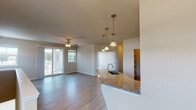 This single-floor residence is designed with a practical, open-concept layout that seamlessly connects the kitchen, dining, and living areas. The kitchen is a standout feature, equipped with dark espresso cabinetry, granite countertops, stainless steel appliances including a range, over-the-range microwave, and refrigerator. A peninsula with an undermount sink and pendant lighting above serves as a natural divider between the kitchen and the expansive living area. The living space benefits from multiple windows that invite natural light throughout, complemented by ceiling fans and sliding glass doors leading to a private balcony with outdoor views.

Bedrooms feature plush carpeting, ceiling fans, and windows with exterior views, providing a comfortable retreat. The bathrooms are finished consistently with granite-topped dark wood vanities and undermount sinks. One bathroom includes a shower-tub combination enclosed by sliding glass doors, while another offers a separate glass-enclosed shower. Hardwood-style flooring flows throughout the main living areas, tying the design together with a clean, cohesive aesthetic throughout the unit.