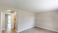 Located at 279 Amherst Rd in Sunderland, MA, this two-story, 2-bedroom, 2-bathroom home offers a well-organized layout across two floors. The main level features a bright living room with large windows that invite natural light and offer pleasant outdoor views, complemented by durable hardwood-style flooring and a baseboard heating system. The entryway provides a welcoming transition into the living space. The kitchen is thoughtfully designed with crisp white shaker-style cabinetry, light stone-finish countertops, and a full suite of stainless steel appliances, including a range, dishwasher, and refrigerator, all set over hardwood-style flooring. A bathroom on the main level features a white vanity with a mirrored medicine cabinet and a tub-shower combination. Upstairs, both bedrooms are generously proportioned, finished with soft wall-to-wall carpeting and neutral gray-toned walls. Each room benefits from wide windows with views of surrounding greenery and includes baseboard heating. The spacious primary bedroom provides ample room for furnishings. A second full bathroom serves the upper level. Hallways on both floors connect the spaces efficiently, contributing to a functional and comfortable flow throughout the home.