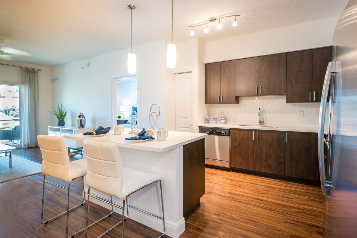 Kitchen with oak cabinetry, white countertops, white tile backsplash, and stainless steel appliances - Avalon Miramar