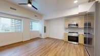 Located at 508 E South Temple Street in Salt Lake City, Utah, this efficiently designed single-floor unit blends modern updates with distinctive character details. The open-plan kitchen and living area is anchored by warm-toned luxury vinyl plank flooring that runs throughout the entire space, creating a cohesive and inviting atmosphere. Elevated ceilings with exposed rustic wood beams add an industrial-chic charm, while recessed lighting and a ceiling fan ensure the space remains well-lit and comfortable. Multiple windows fitted with horizontal blinds allow ample natural light to fill the living area, enhancing its open feel. The kitchen is well-appointed with light wood cabinetry featuring gold hardware, a full suite of stainless steel appliances including a gas range, built-in microwave, dishwasher, and refrigerator, complemented by a clean white countertop and a modern matte black faucet at the sink. The bathroom continues the contemporary aesthetic with matching light wood vanity cabinetry, a white soaking tub and shower combination, and a bright window that introduces natural light. White walls throughout provide a clean, neutral backdrop, making the space feel bright and versatile.